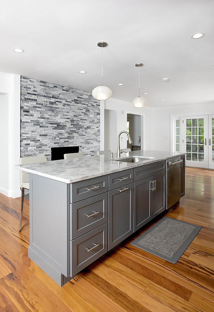 View of the island area and fireplace area AFTER work on this kitchen remodel in West Hartford.