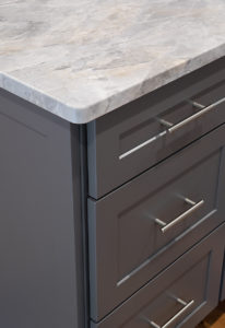 Detail of the matching drawer fronts and the beautiful patterns of the Super White Quartzite showing the custom eased edge.