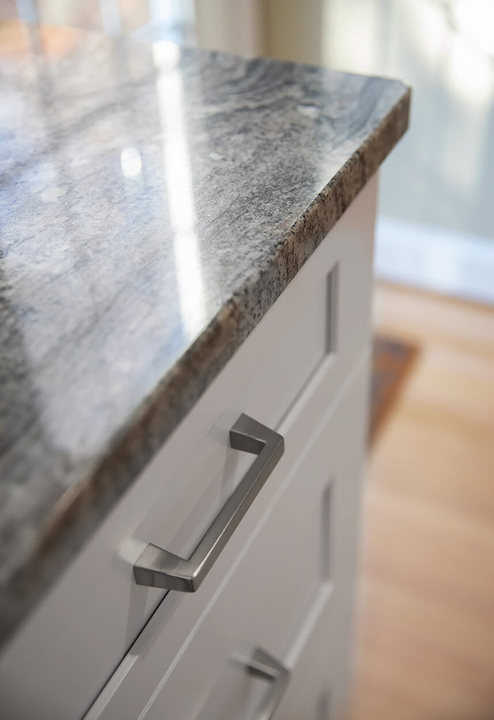 Detail of White Wave Granite counters with brushed nickel bar pulls by Richelieu.