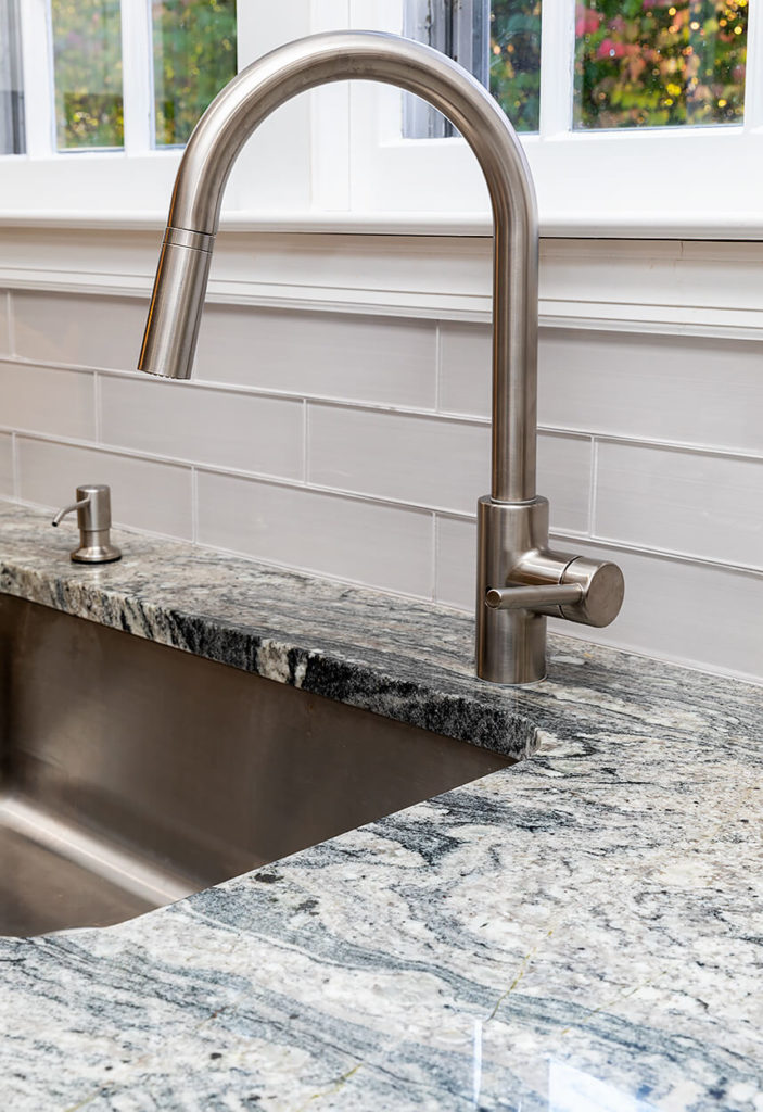 Detail of White Wave Granite counters and gray tile backsplash.
